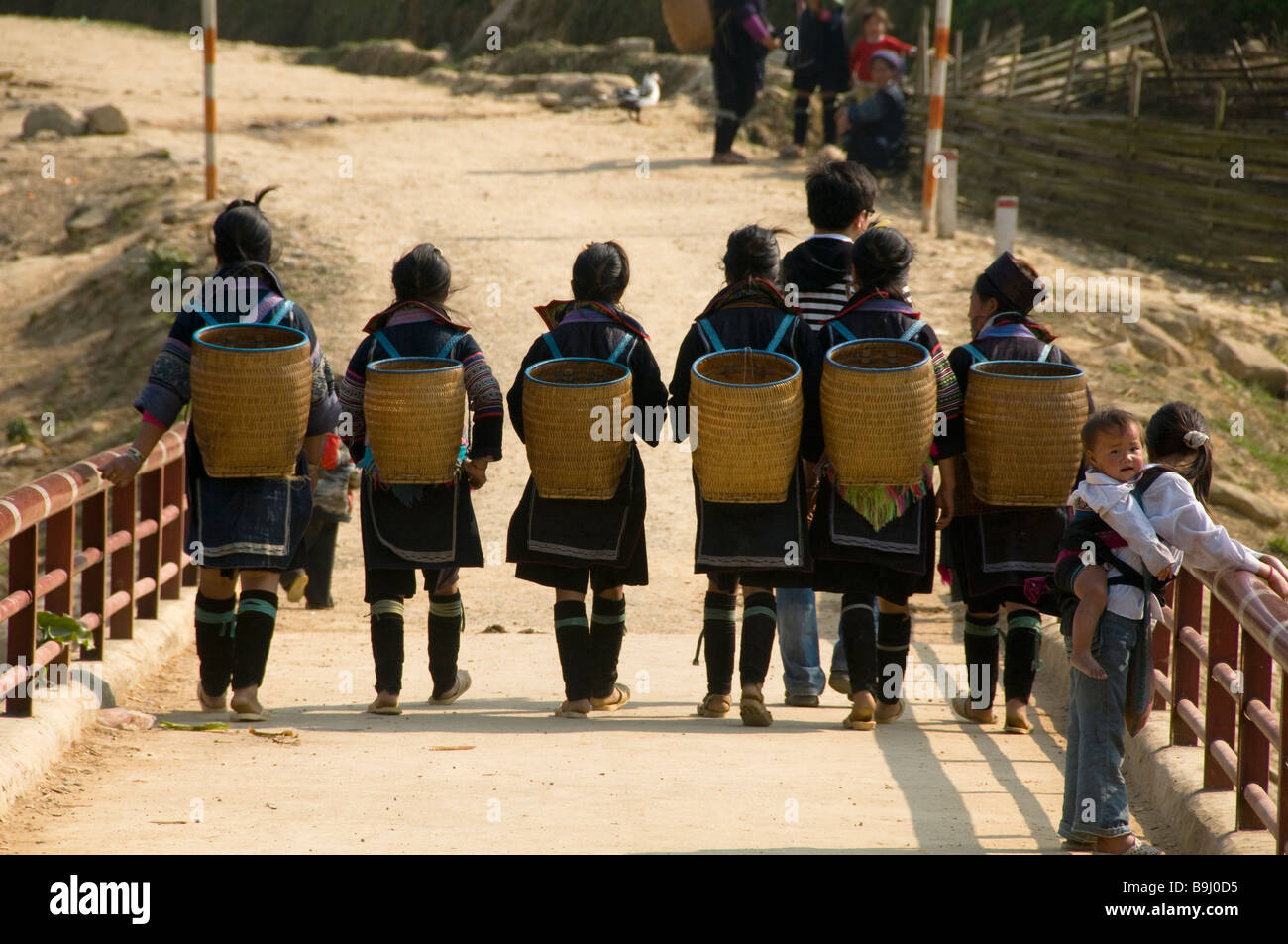 Black Hmong Frauen und ihre Körbe zu Fuß in der Nähe von Sapa Vietnam Stockfoto
