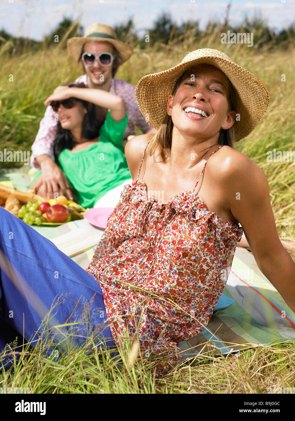 Freunde mit einem Picknick in einem Feld Stockfoto