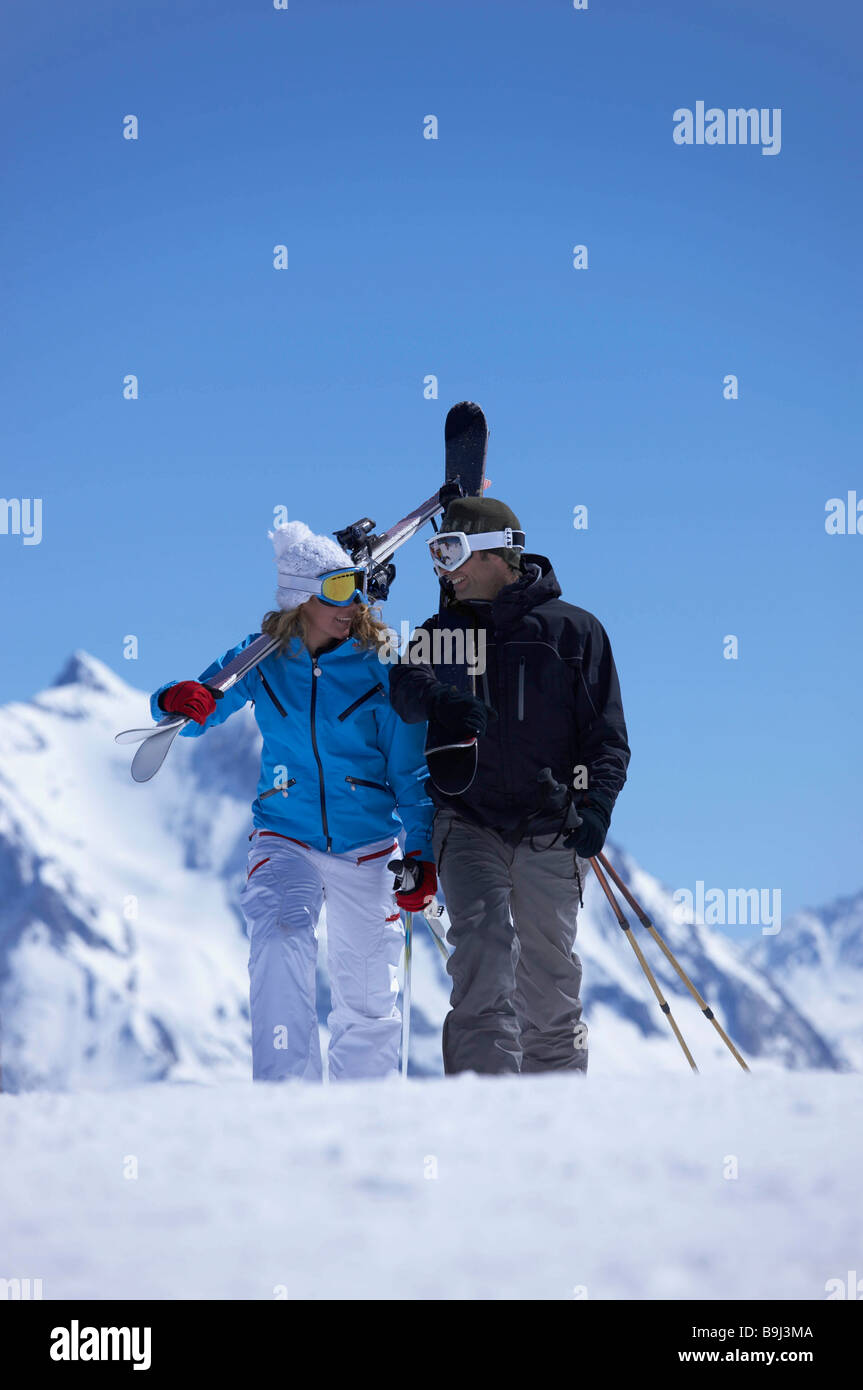 Paare, die mit den Skiern über die Schulter Stockfoto