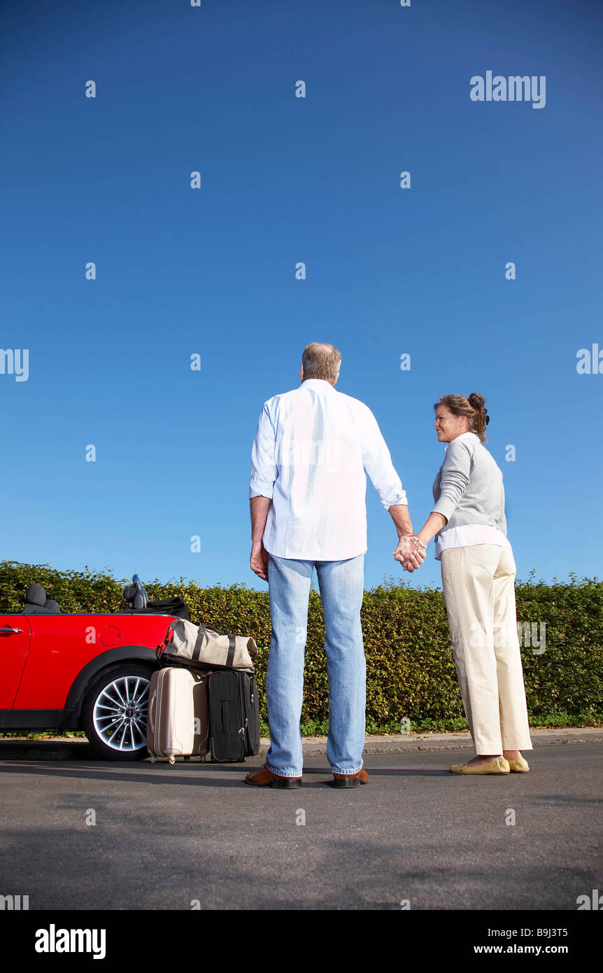 Paar Hand in Hand mit dem Auto Stockfoto