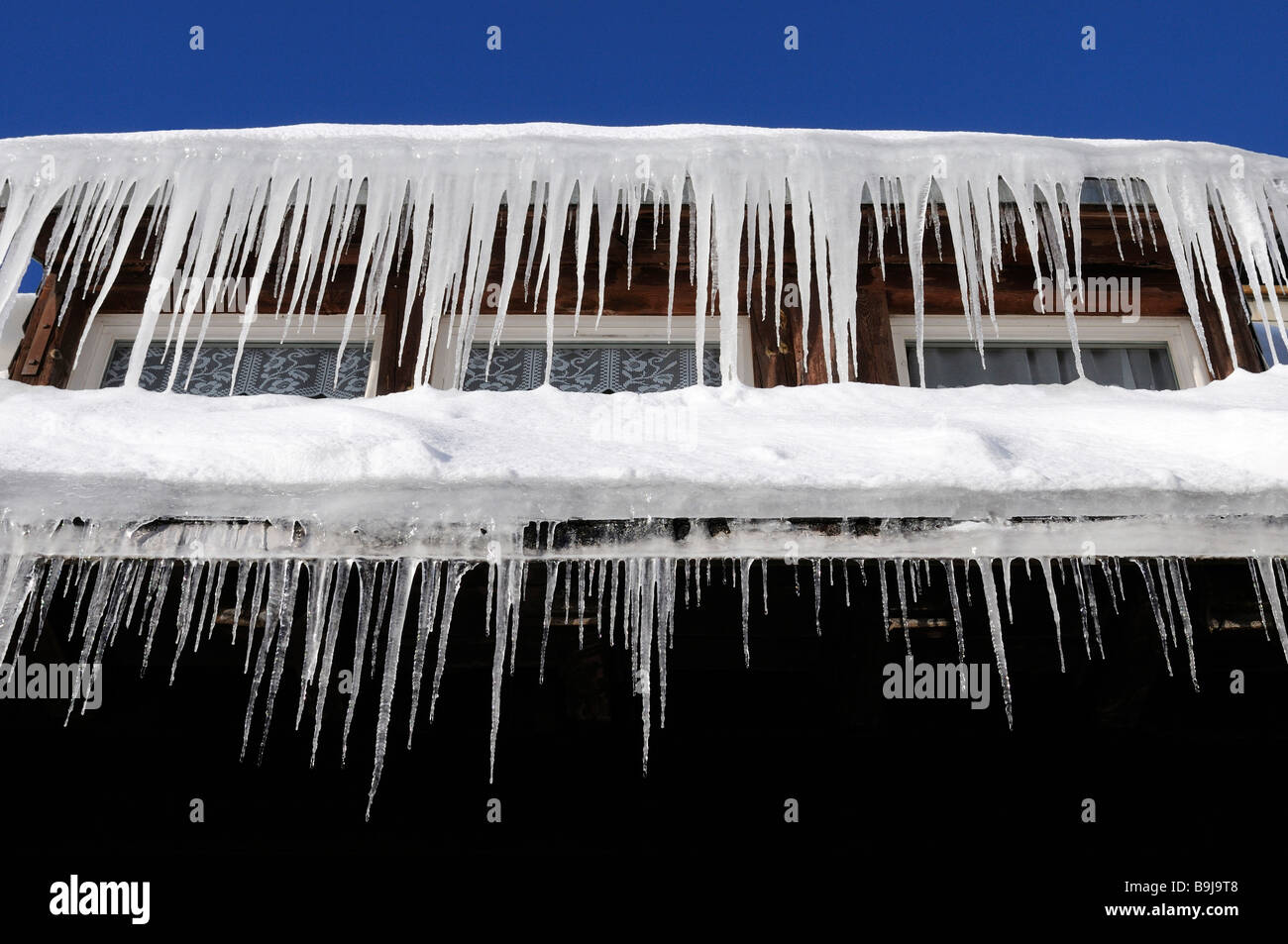 Eiszapfen hängen von einer Dachrinne Stockfoto