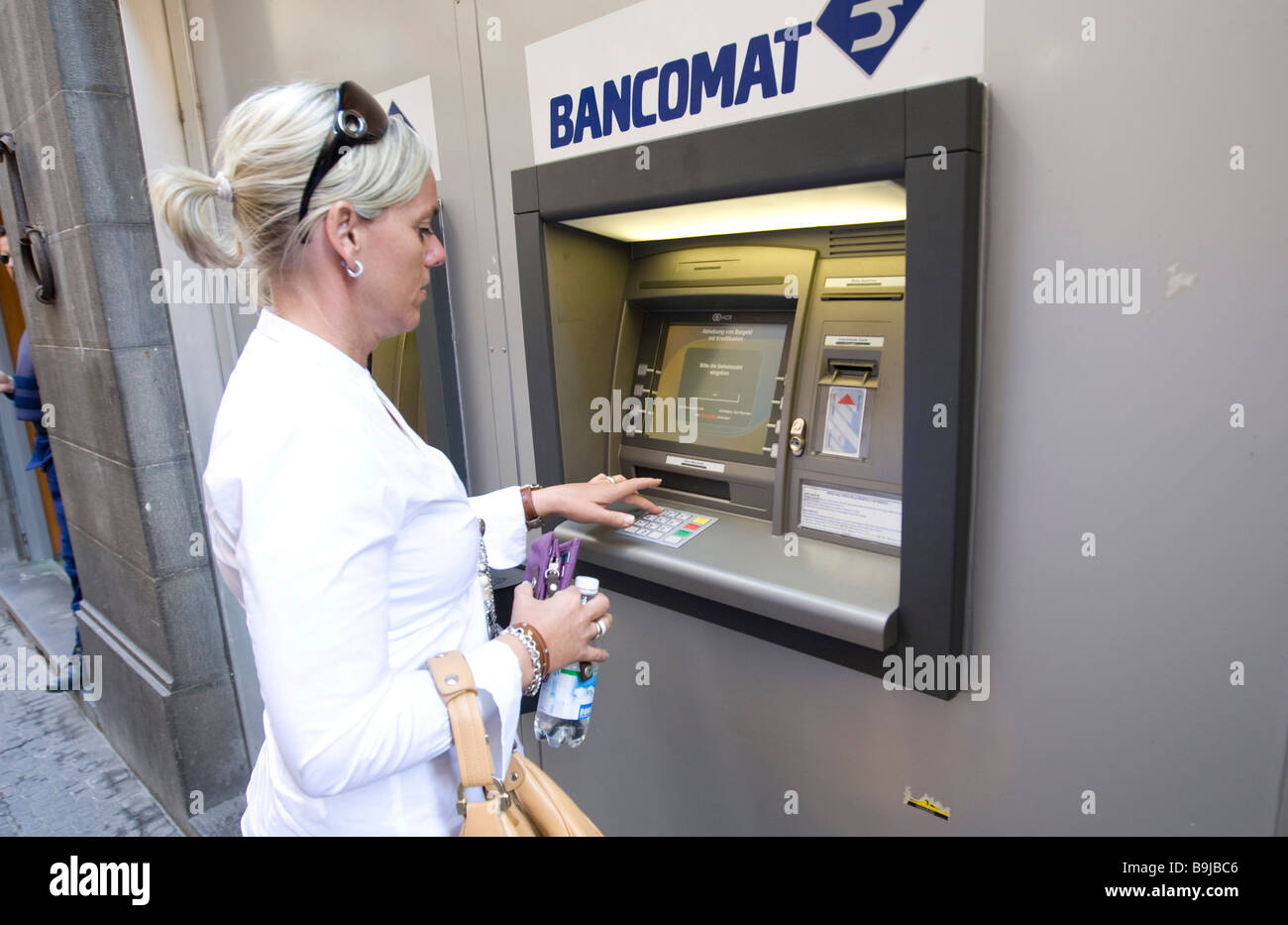 Frau bekommen Geld von einem Geldautomaten in Siena, Toskana, Italien, Europa Stockfoto