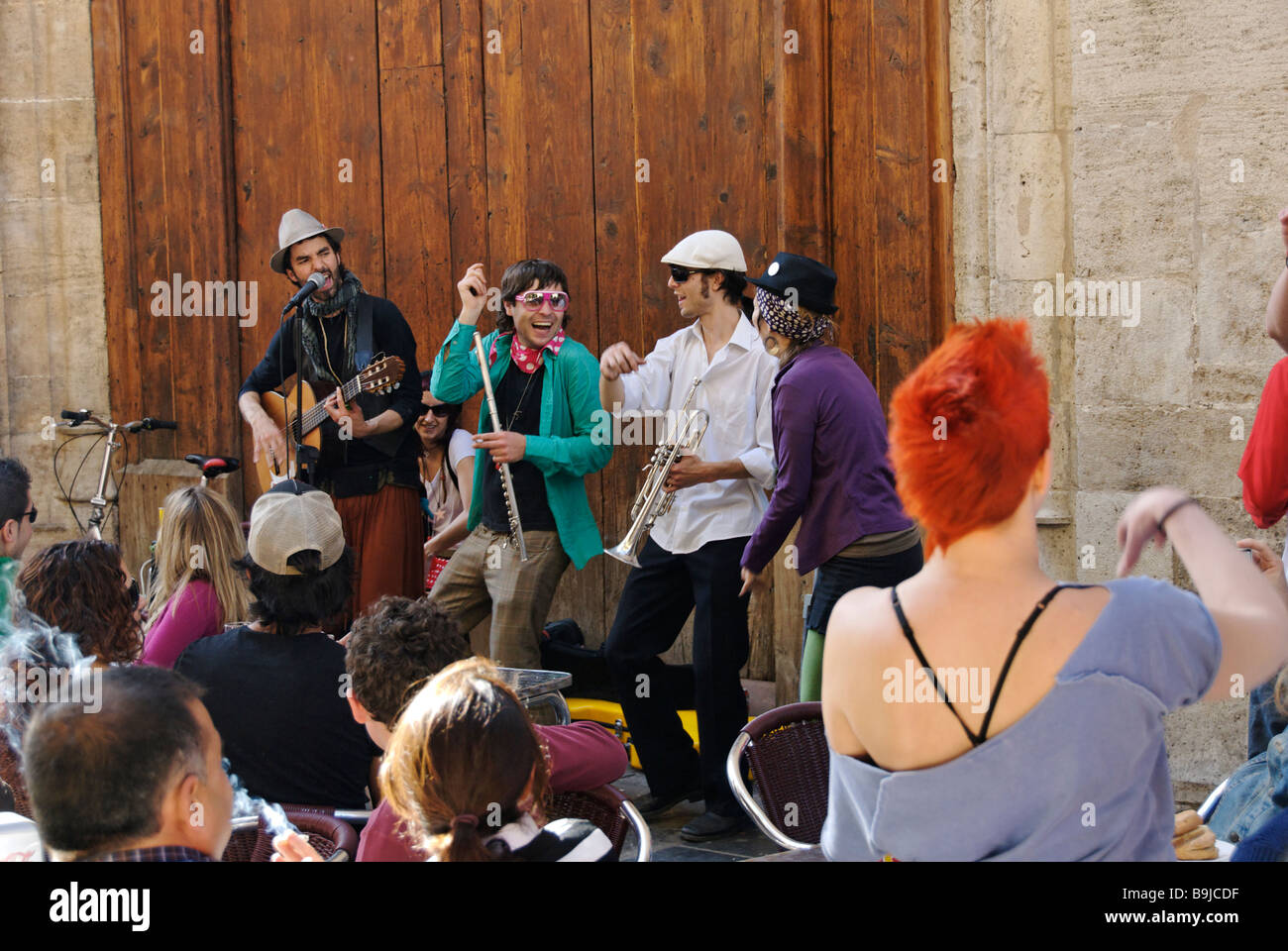 Junge Leute hören ein Band als Straßenmusikant während Las Fallas Festival im historischen Stadtzentrum von Valencia, Spanien Stockfoto