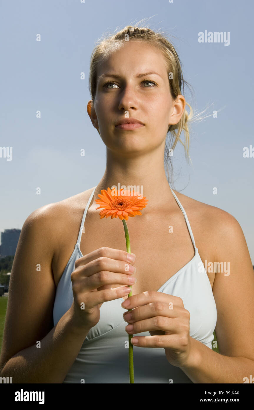 Frau junge blonde Gerbera-Blüte-Portrait-Serie Menschen Top String Top Blume Gerbera Sommerblume Entspannung Erholung Stockfoto