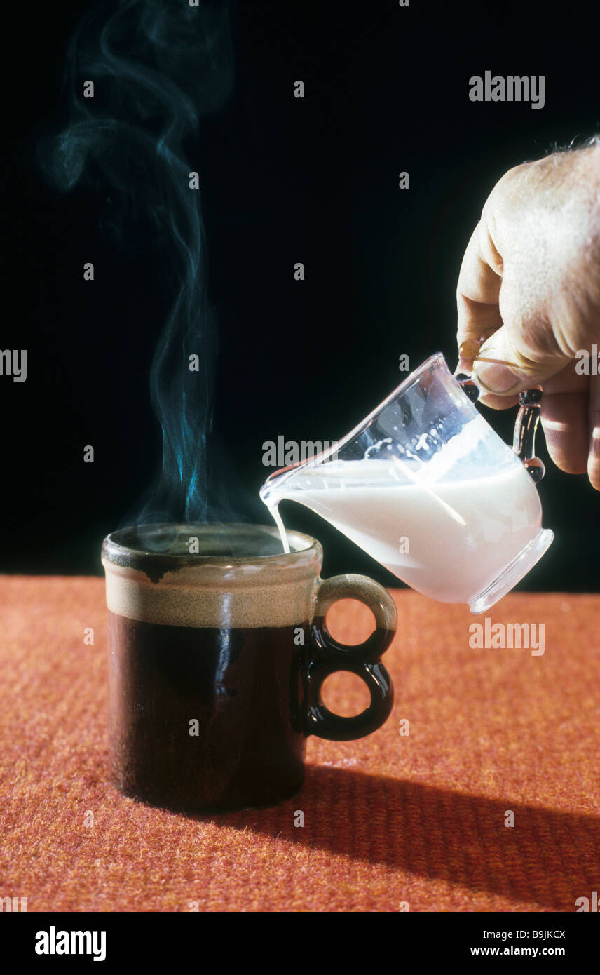 Kalte Milch in heißen Kaffee Becher Dampf Rauch Aufstieg Physik Chemie Geschmack Temperatur Mischung gießen reagieren konvertieren Stockfoto