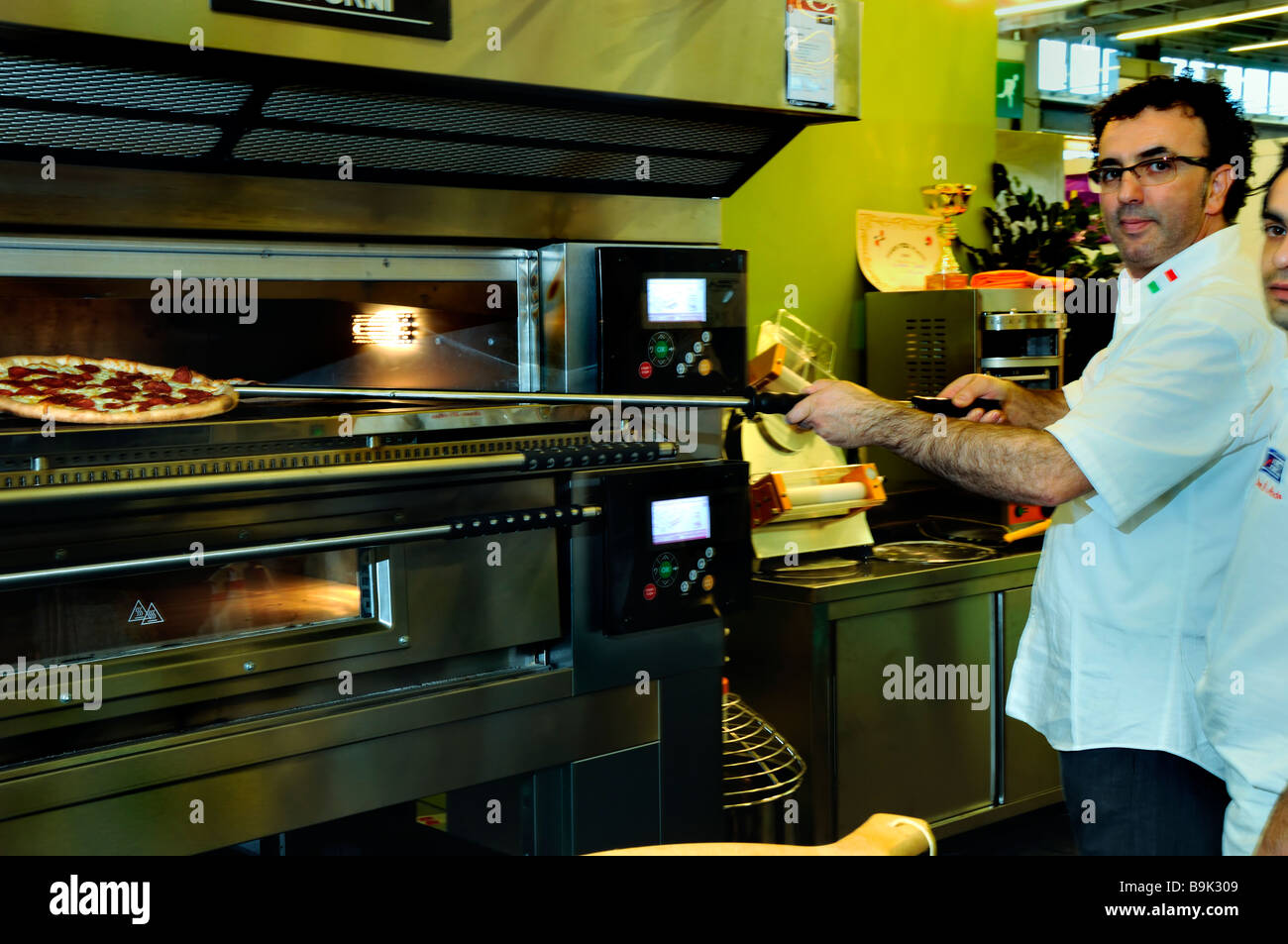 PARIS FRANKREICH, Pizza Chef Trade Show Oven, Koch kocht Pizza bei 'Moretti Forni' Company, Pizzeria, Pizza Restaurant Innenausstattung, kommerzielle Küche Stockfoto