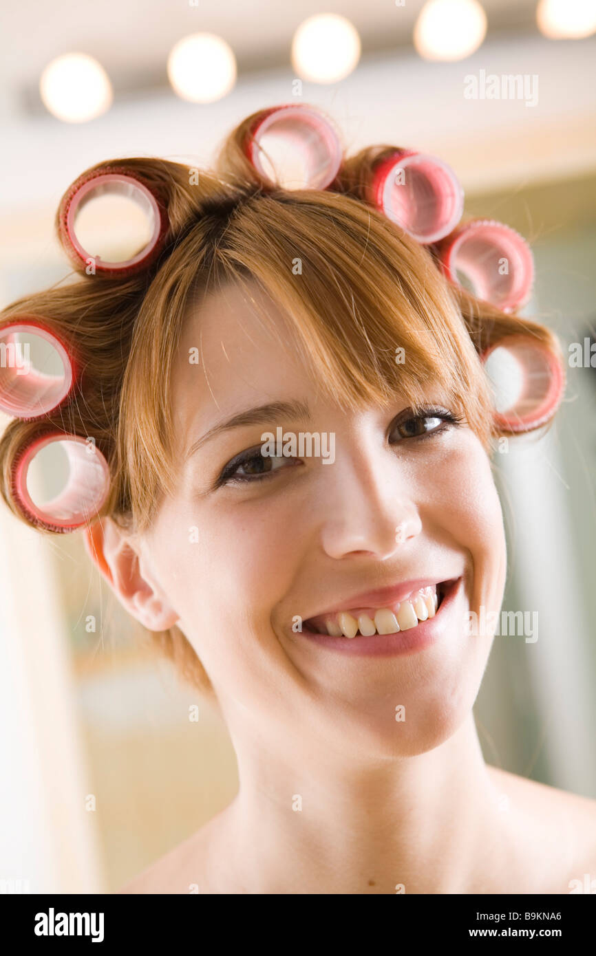 Junge Frau mit Lockenwickler auf dem Kopf Stockfoto