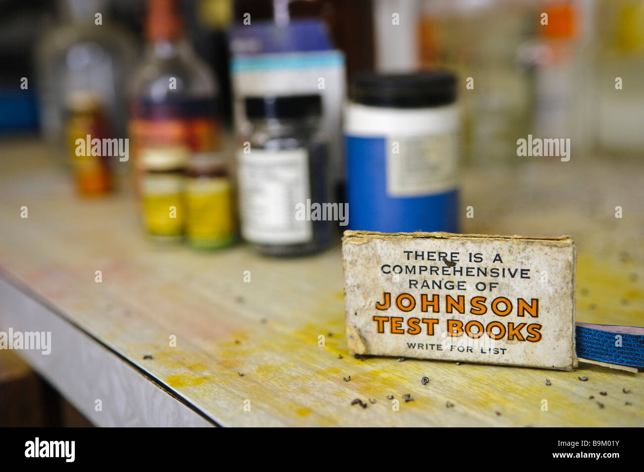 Box mit Johnson Test Bücher auf einem unordentlichen Labortisch mit Flaschen und Gläser von Chemikalien im Hintergrund. Stockfoto