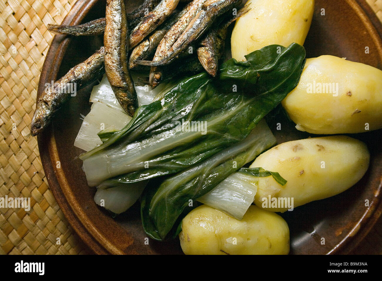 Einfach lecker gesundes herzhaftes Abendessen gekochte Kartoffel mit gebratenen Sardinen und Mangold, gewürzt mit Olivenöl Stockfoto