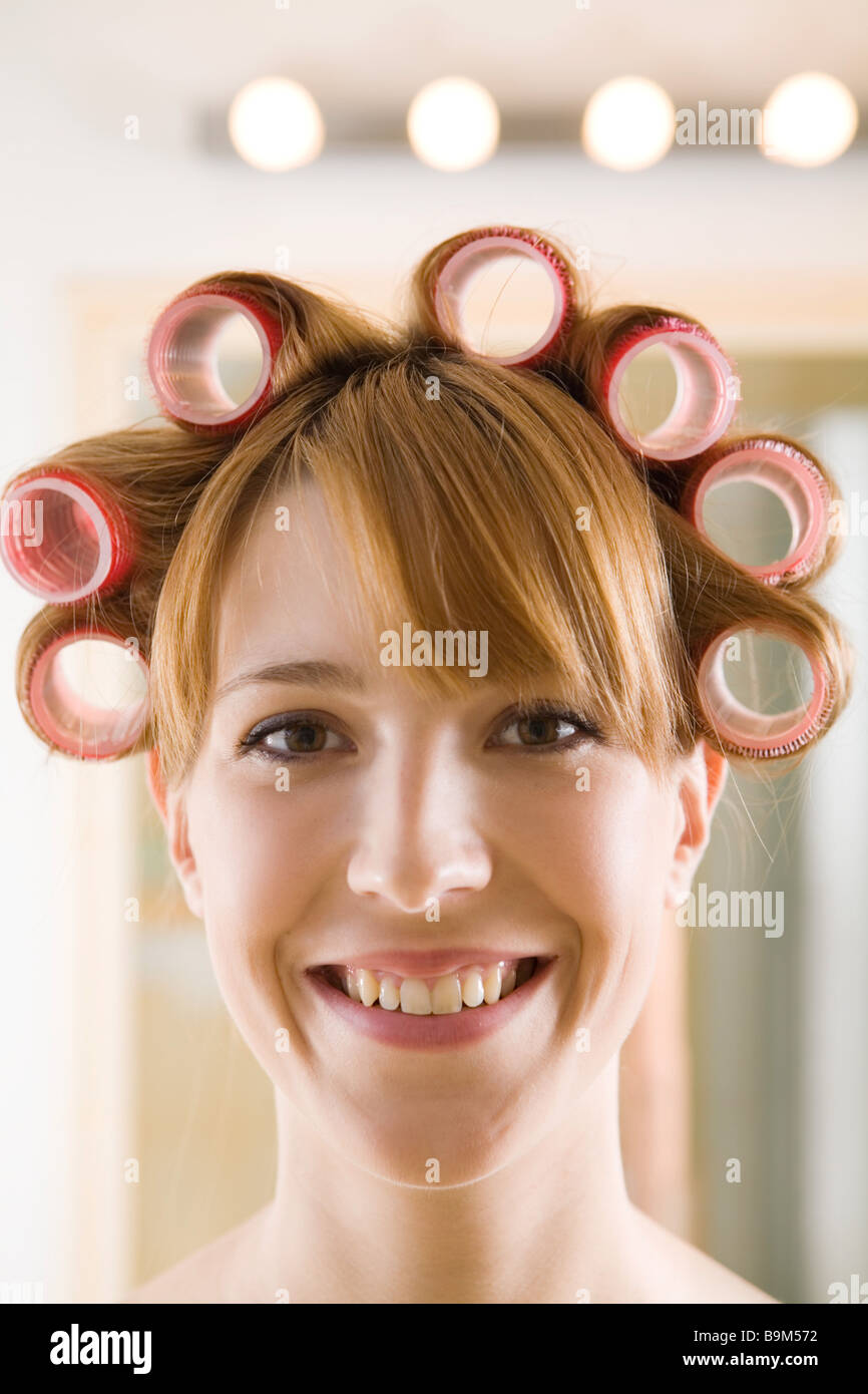 Junge Frau mit Lockenwickler auf dem Kopf Stockfoto