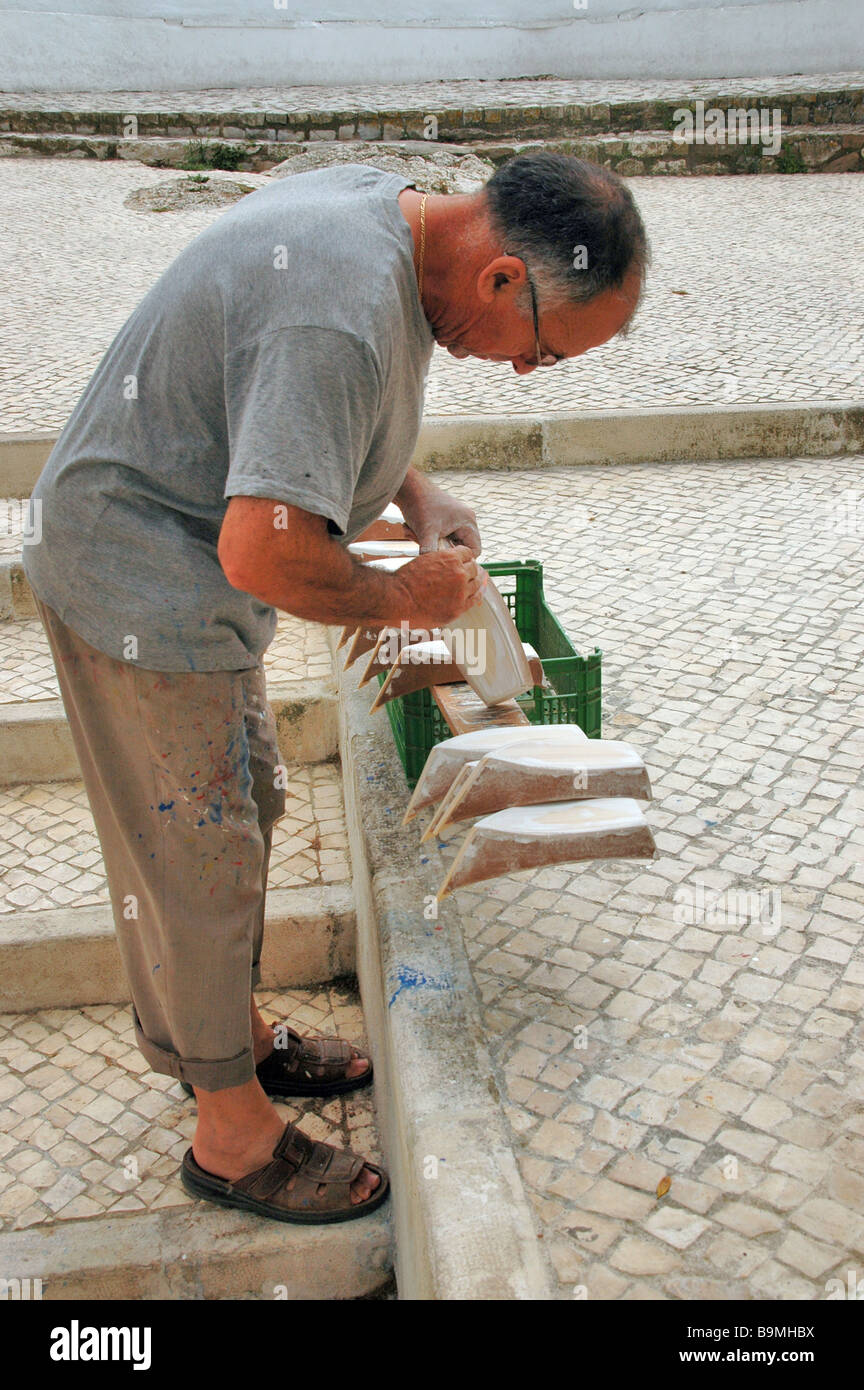 Ein Handwerker macht Modelle der traditionellen Fischerboote von Nazare, Portugal für den Tourismus. Stockfoto