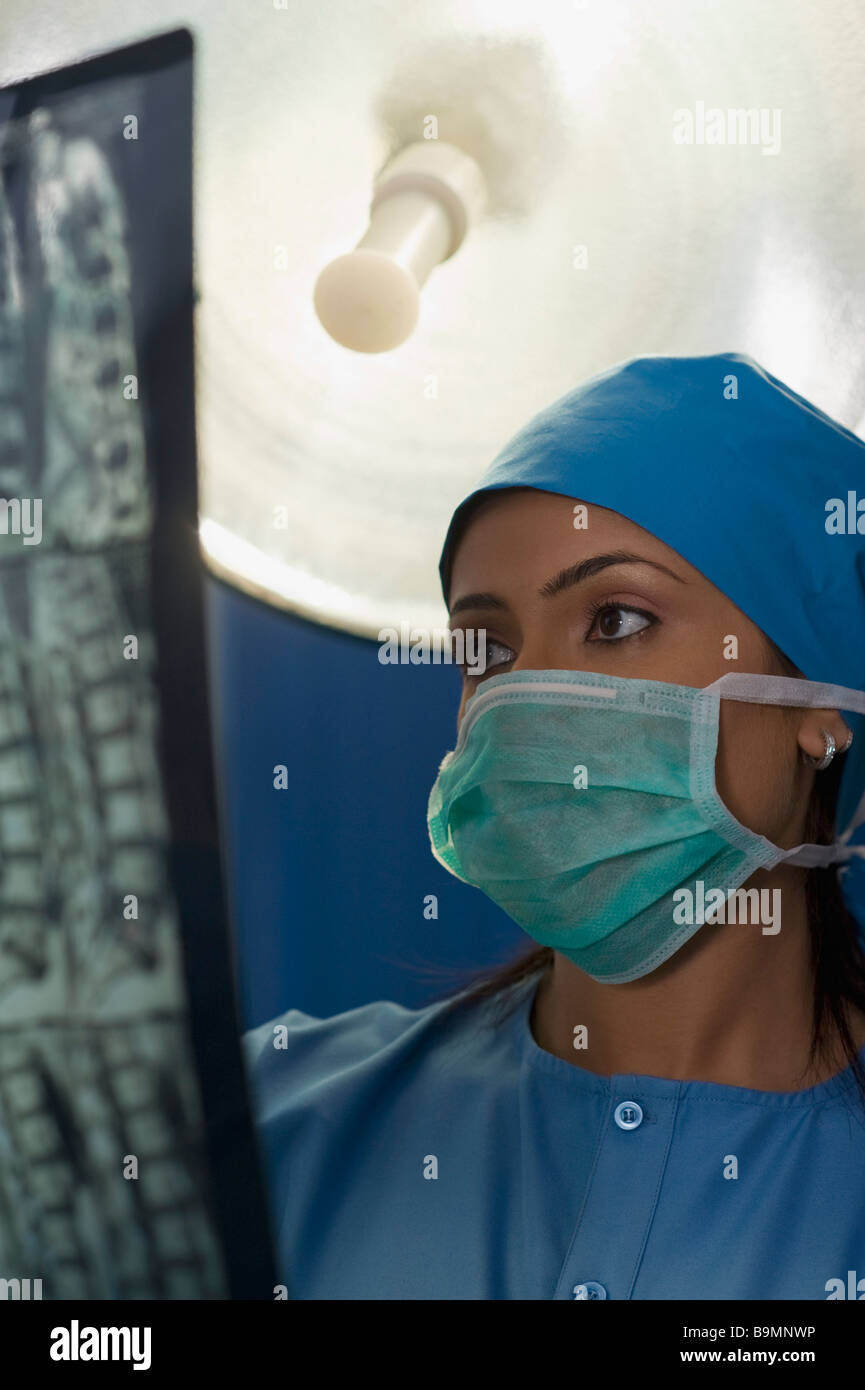 Weibliche Chirurg untersuchen einen Röntgen-Bericht Stockfoto