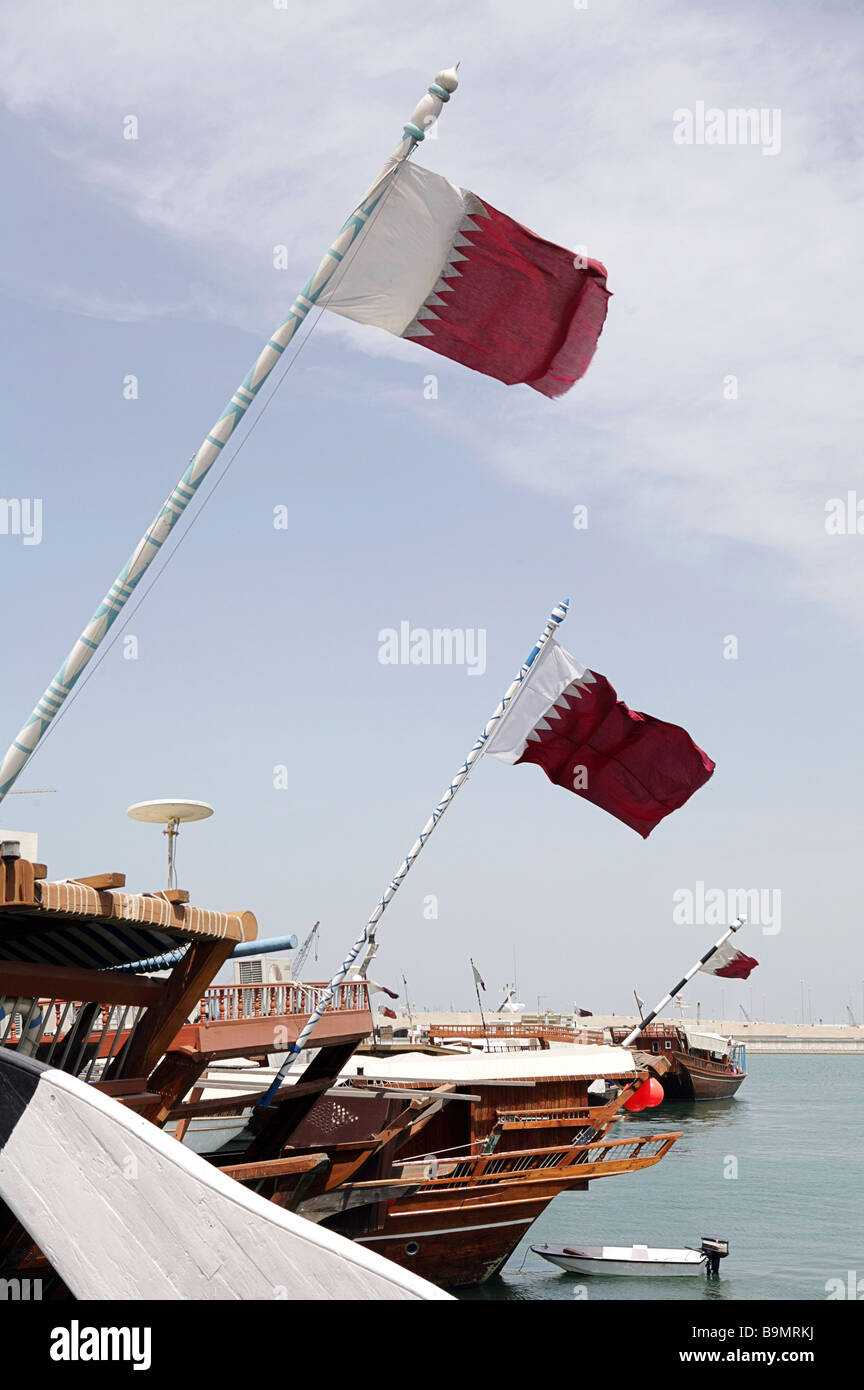 Dhaus gefesselt in der Dhau-Hafen, Katar, mit der nationalen Flagge, die von ihrer strengen maßstabsgerechte fliegen. Stockfoto