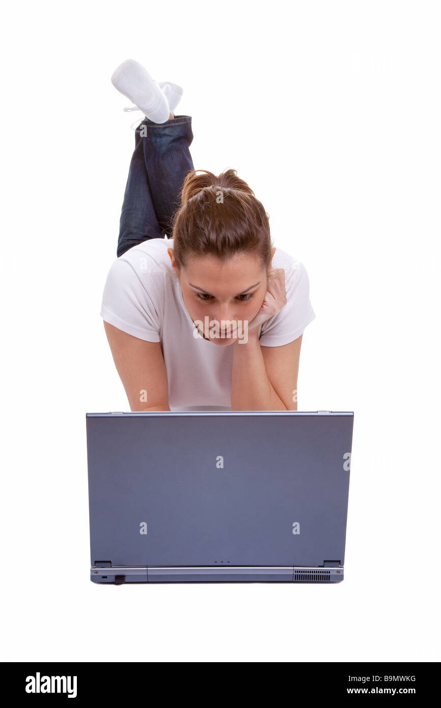 Hübsche junge Frau liegend auf einem Laptopcomputer isoliert auf weißem Hintergrund arbeiten Stockfoto