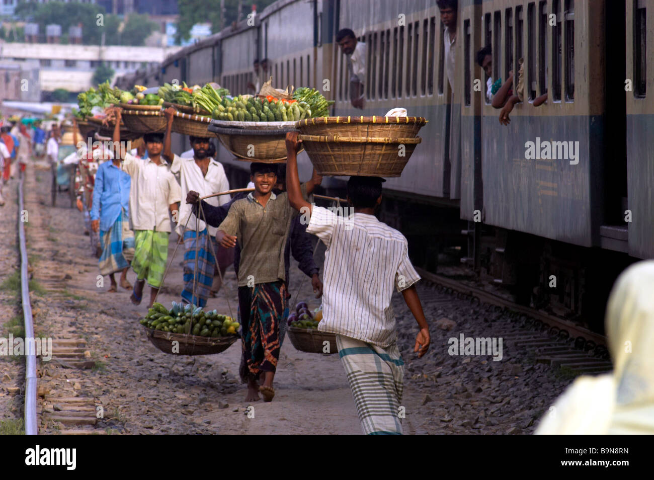 Männer tragen produzieren Korb auf Kopf Arbeit Bahnstrecke Stockfoto