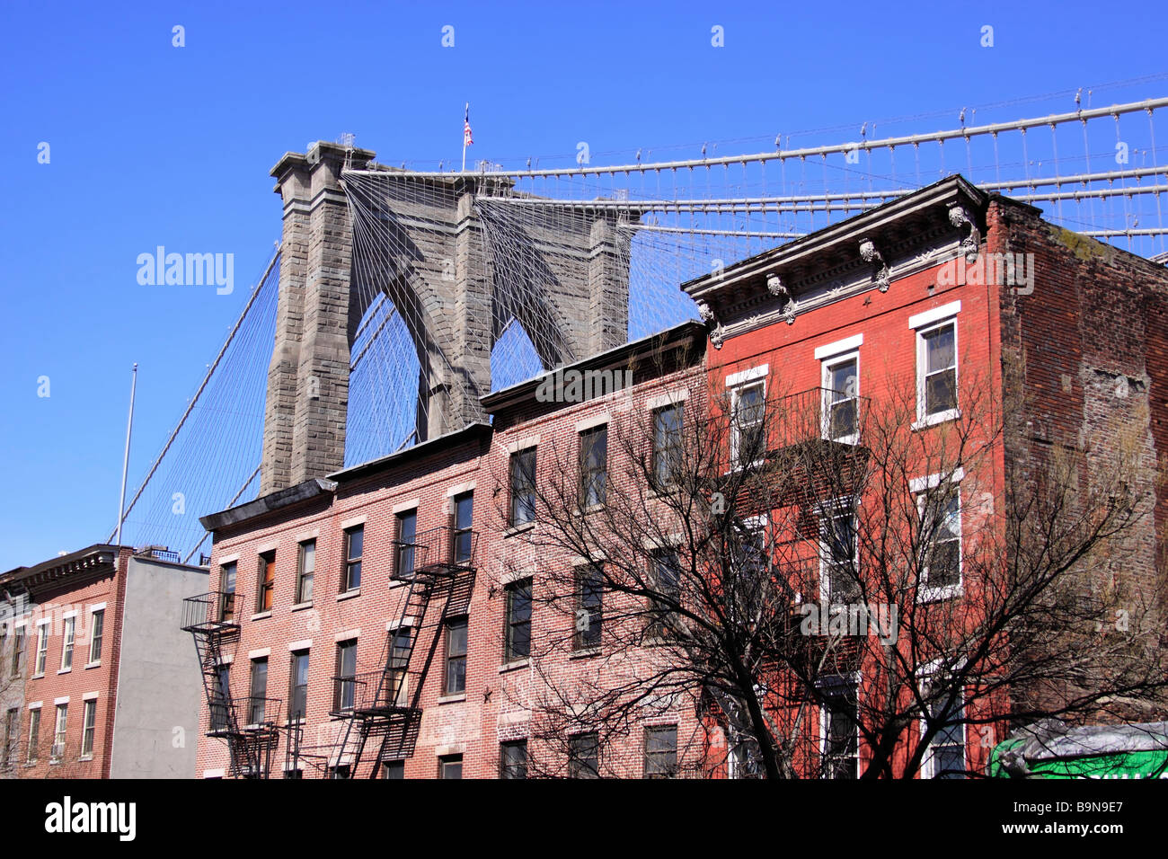 Die Brooklyn Bridge, überragt von Altbauten auf Fulton Street, Brooklyn, New York City, USA Stockfoto