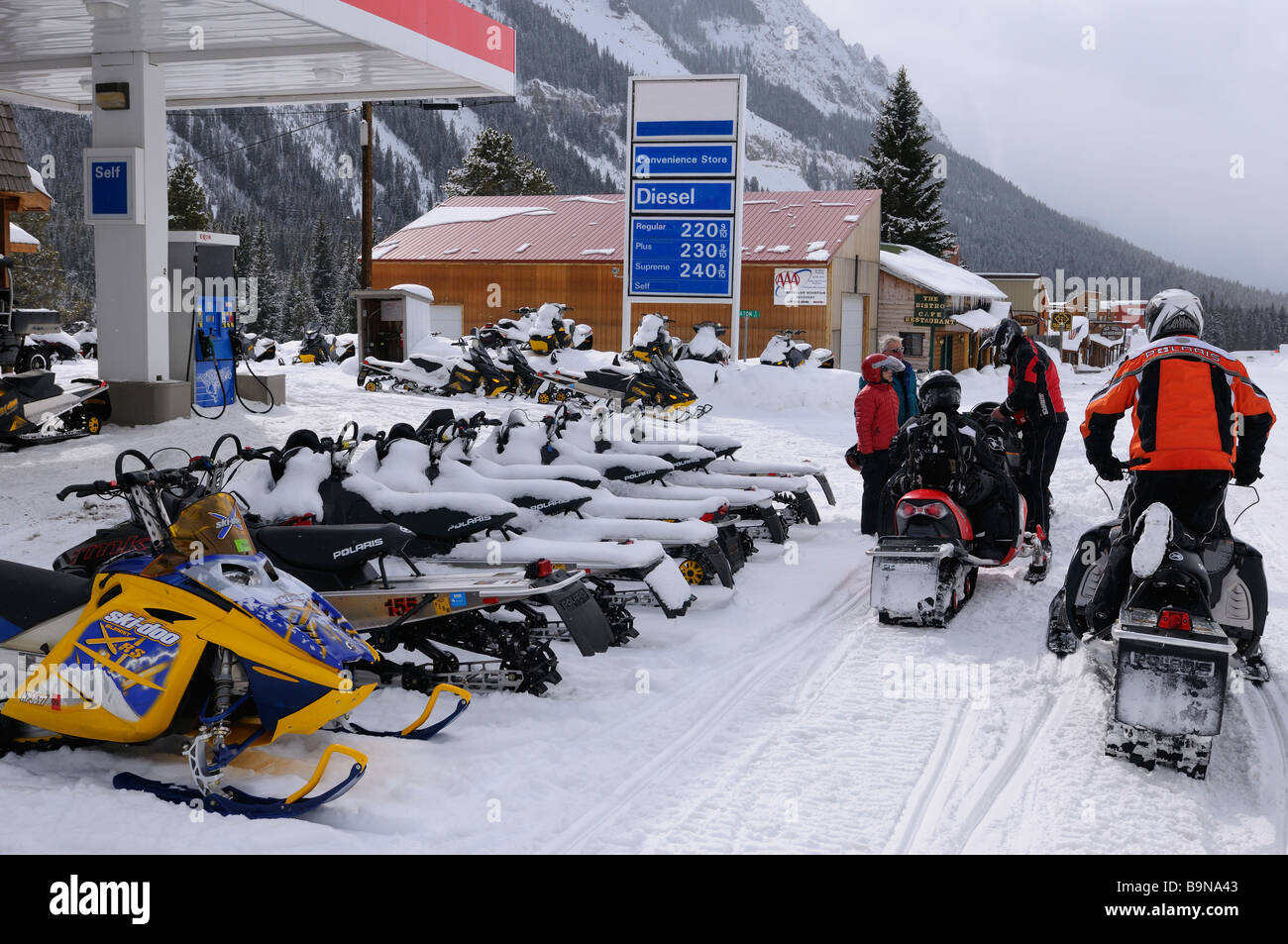 Motorschlitten an einer Tankstelle im Winter Cooke City Montana USA Eingang zum Yellowstone republikanische Berg Stockfoto