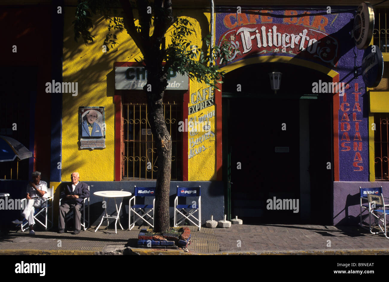 Zwei alte Männer genießen Sie die Sonne vor einer Cafébar in La Boca, dem Künstlerviertel von Buenos Aires, Argentinien. Stockfoto