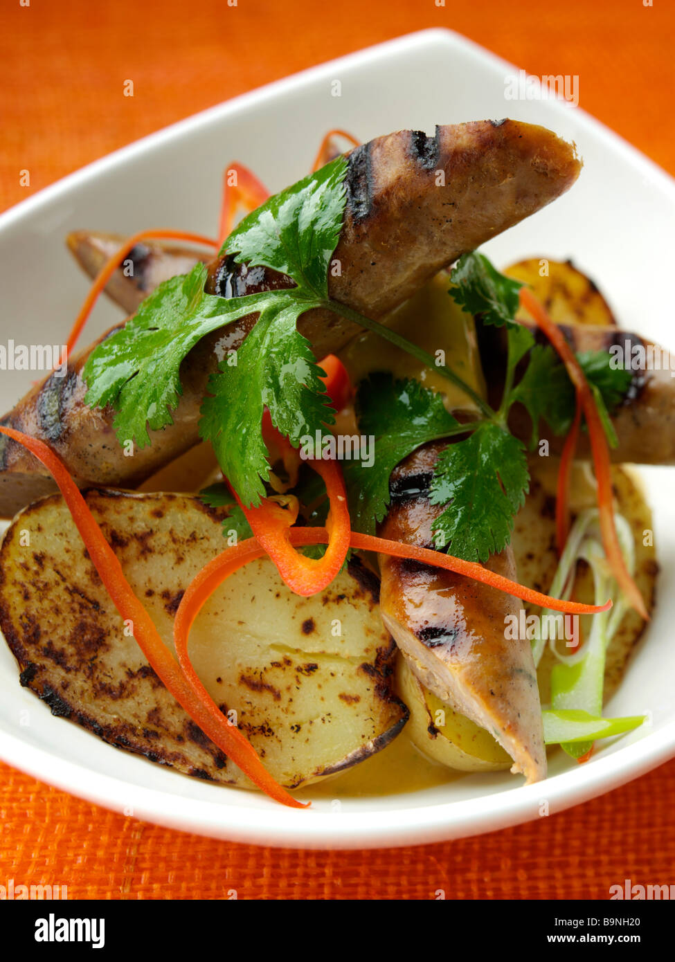 Merguez-Würstchen mit geräuchertem Frühkartoffeln und Harrissa mayonnaise Stockfoto