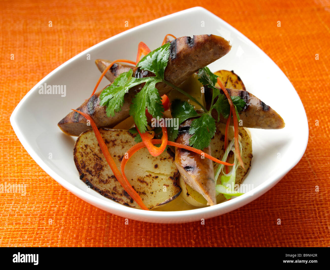 Merguez-Würstchen mit geräuchertem Frühkartoffeln und Harrissa mayonnaise Stockfoto