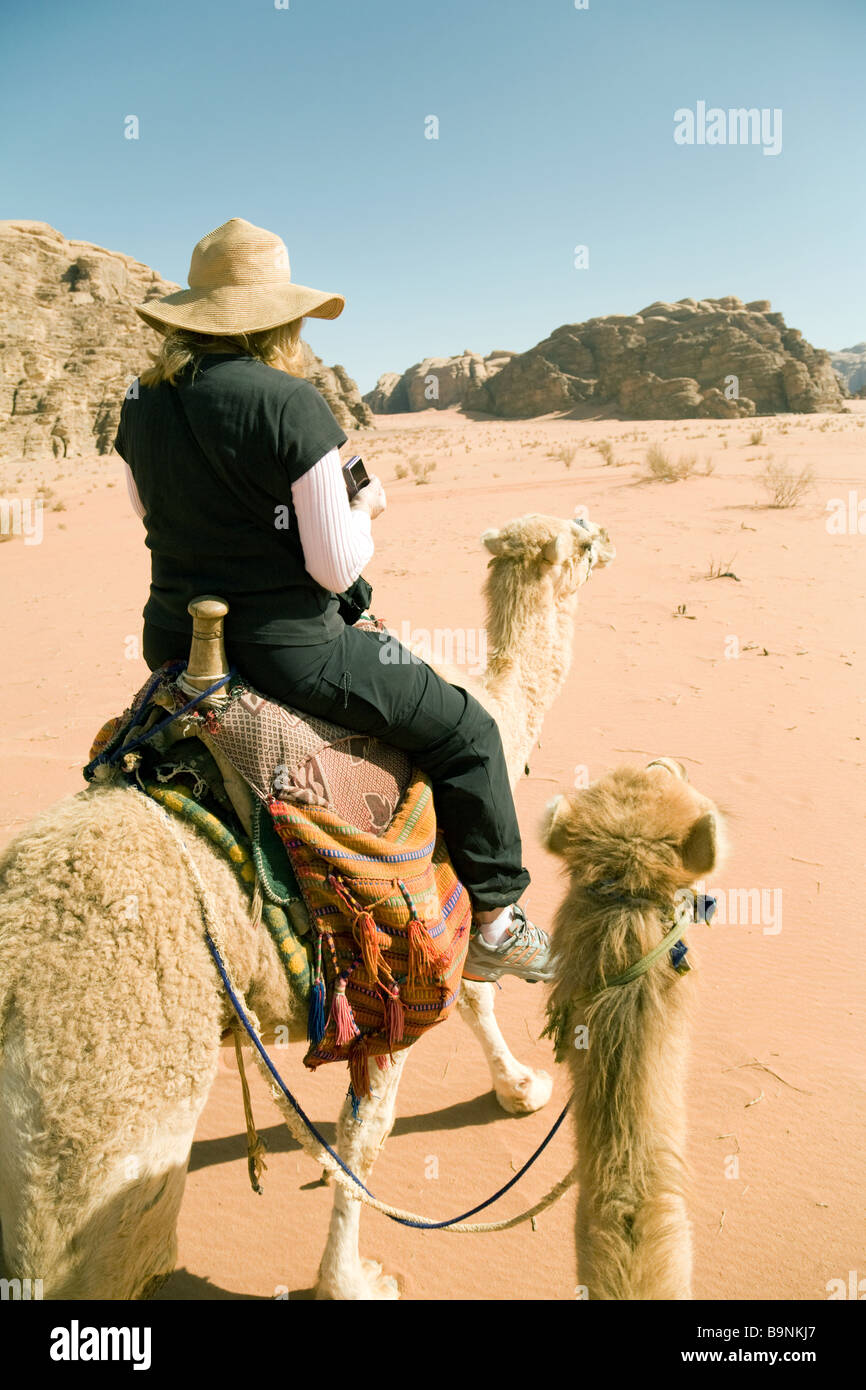 Eine Frau touristische reiten auf einem Kamel in die Wüste, Wadi Rum, Jordanien, Naher Osten Stockfoto