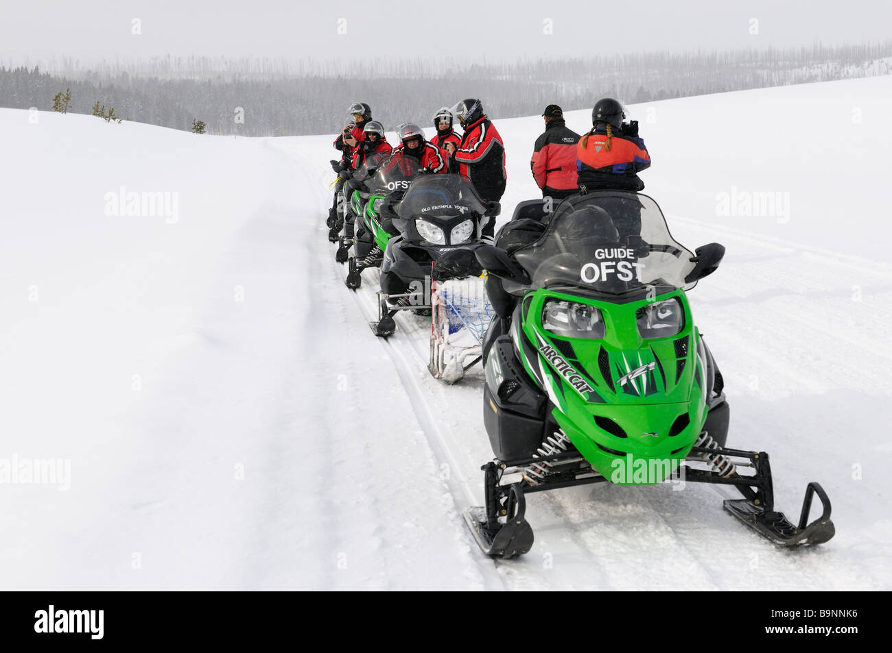 Schneemobil-Gruppe, die im Winter für Bilder auf Norris Canyon Road in Yellowstone National Park in Wyoming USA gestoppt Stockfoto