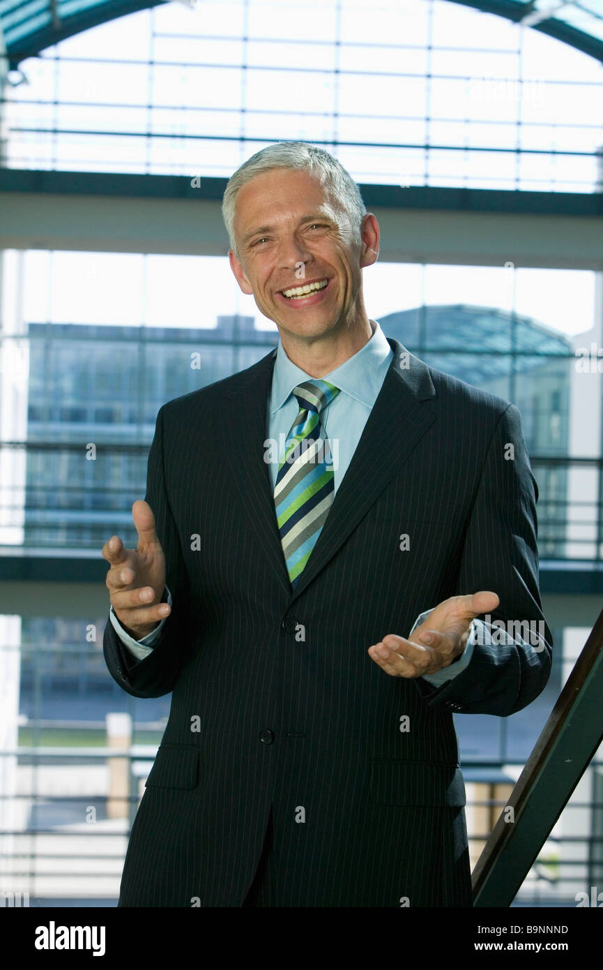 Porträt von reifer Geschäftsmann einladende Geste Stockfoto