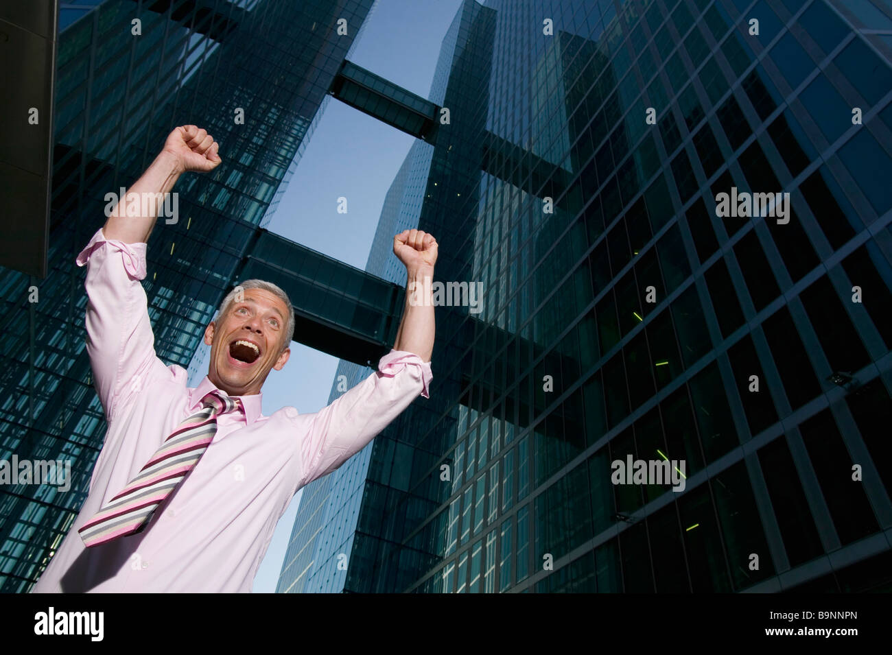 niedrigen Winkel Porträt von reifer Geschäftsmann vor Bürogebäude feiern Stockfoto