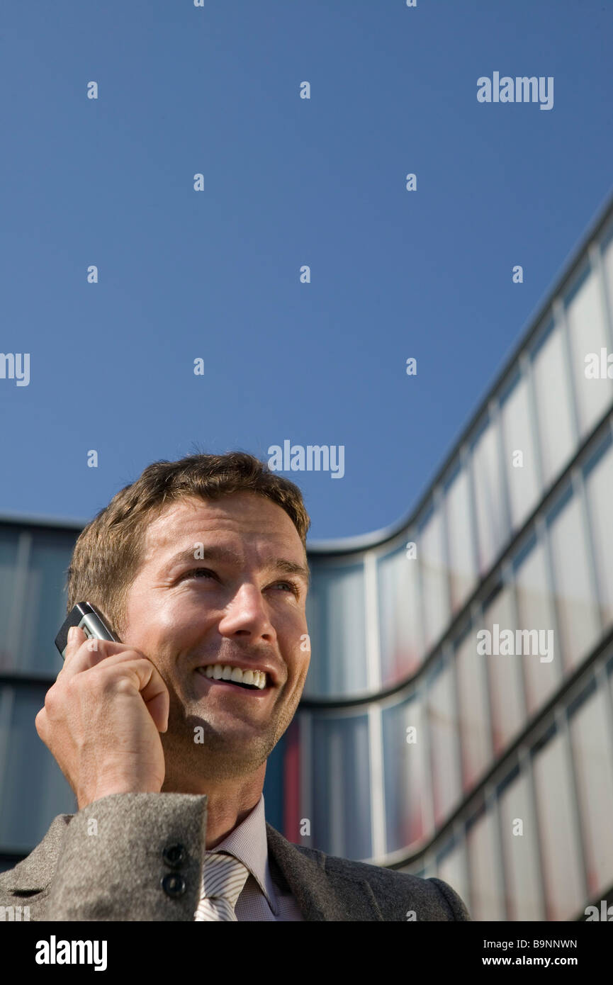 Porträt des Kaufmanns telefonieren mit Handy vor Bürogebäude Stockfoto