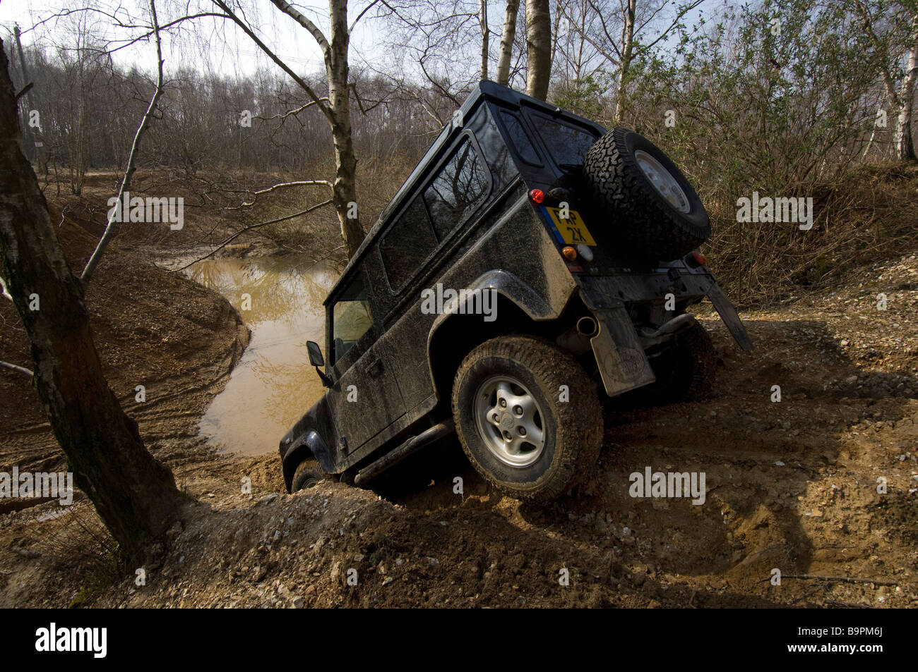 Ein Land Rover Defender 90 schleicht sich eine steile Böschung hinunter Stockfoto