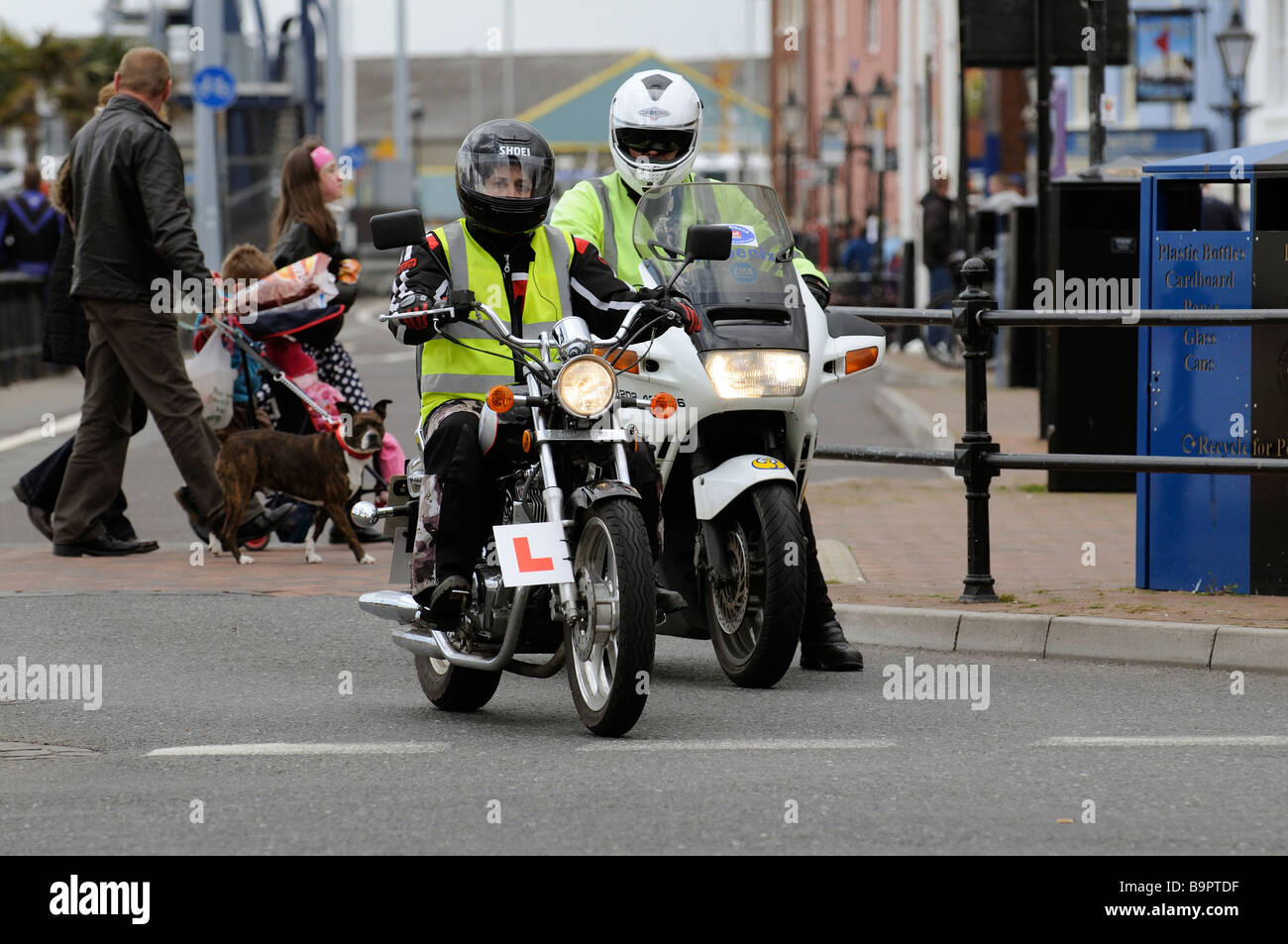 Motorrad-Ausbildungsprogramm einen jungen Motorradfahrer unter der Anleitung von seinem fortschrittlichen Lehrer an einer Straßenkreuzung in Poole Stockfoto