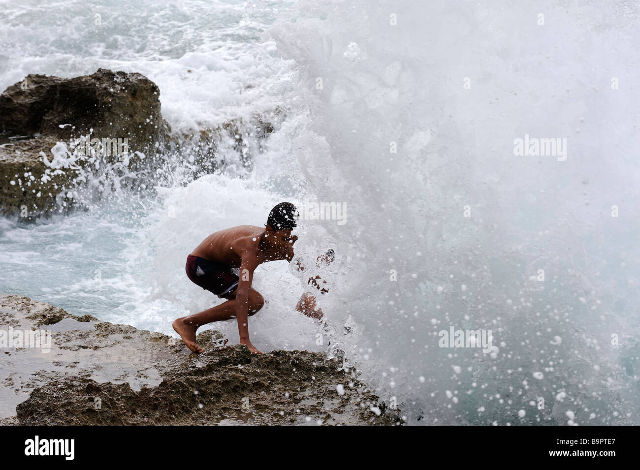 Junge ducking unter einer eingehenden Welle am Malecon in Havanna, Kuba Stockfoto