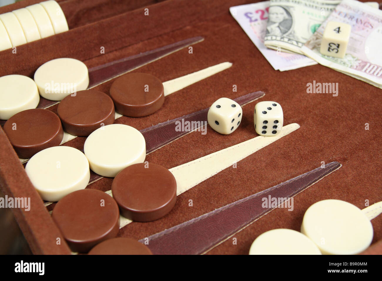 Backgammon-Spiel im Gange, die Spielsteine, Würfel und Einsatz zeigen. Stockfoto