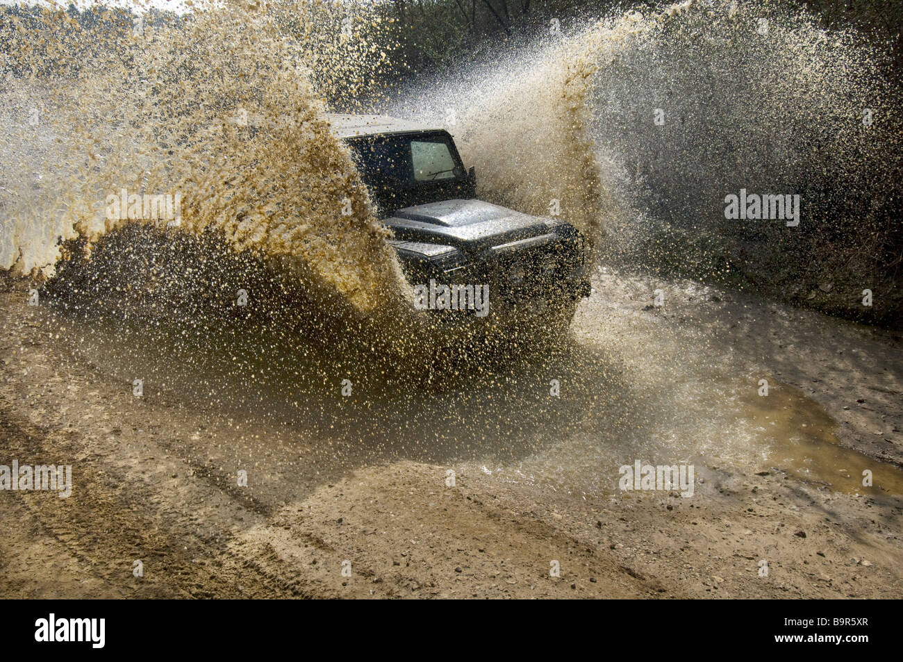 Ein Land Rover Defender 90 auf einer überfluteten Straße. Stockfoto