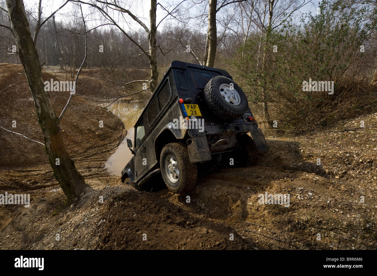 Ein Land Rover Defender 90 fahren eine steile Böschung hinunter während einer Off Road-Übung Stockfoto