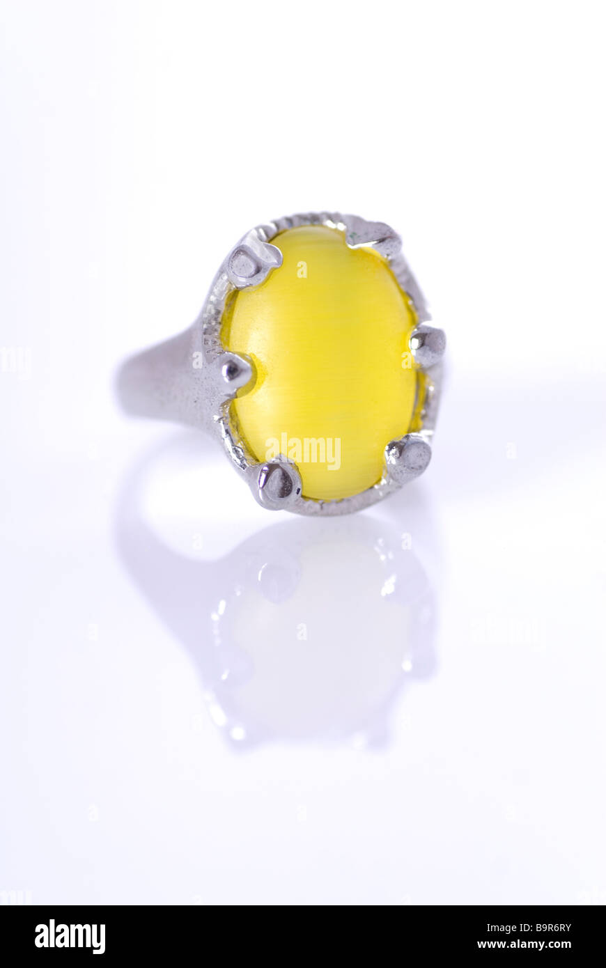 Ring mit einem großen gelben Edelstein vor einem weißen Hintergrund Stockfoto