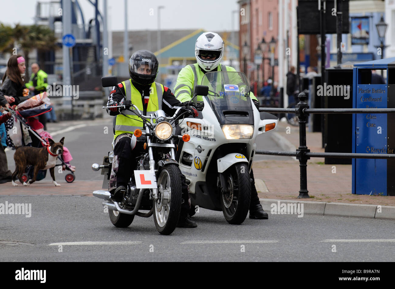 Motorrad-Ausbildungsprogramm einen jungen Motorradfahrer unter der Anleitung von seinem fortschrittlichen Lehrer an einer Straßenkreuzung in Poole Stockfoto