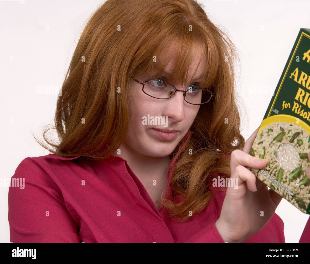 Eine Frau sorgfältig liest die Produktinformationen auf einem Lebensmittelpaket Stockfoto