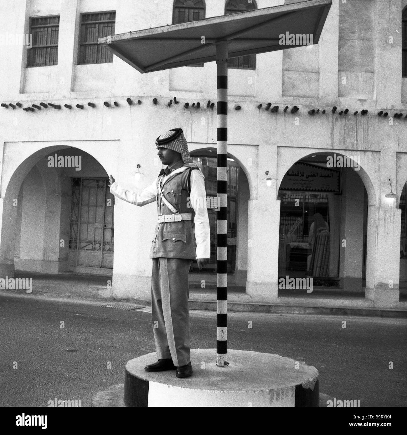 Eine Polizist Regie Verkehr in Katar s Souq Waqif Retro-Stil Einkaufsviertel, die Uniformen der 1960er Jahre haben für Touristen wieder belebt worden Stockfoto