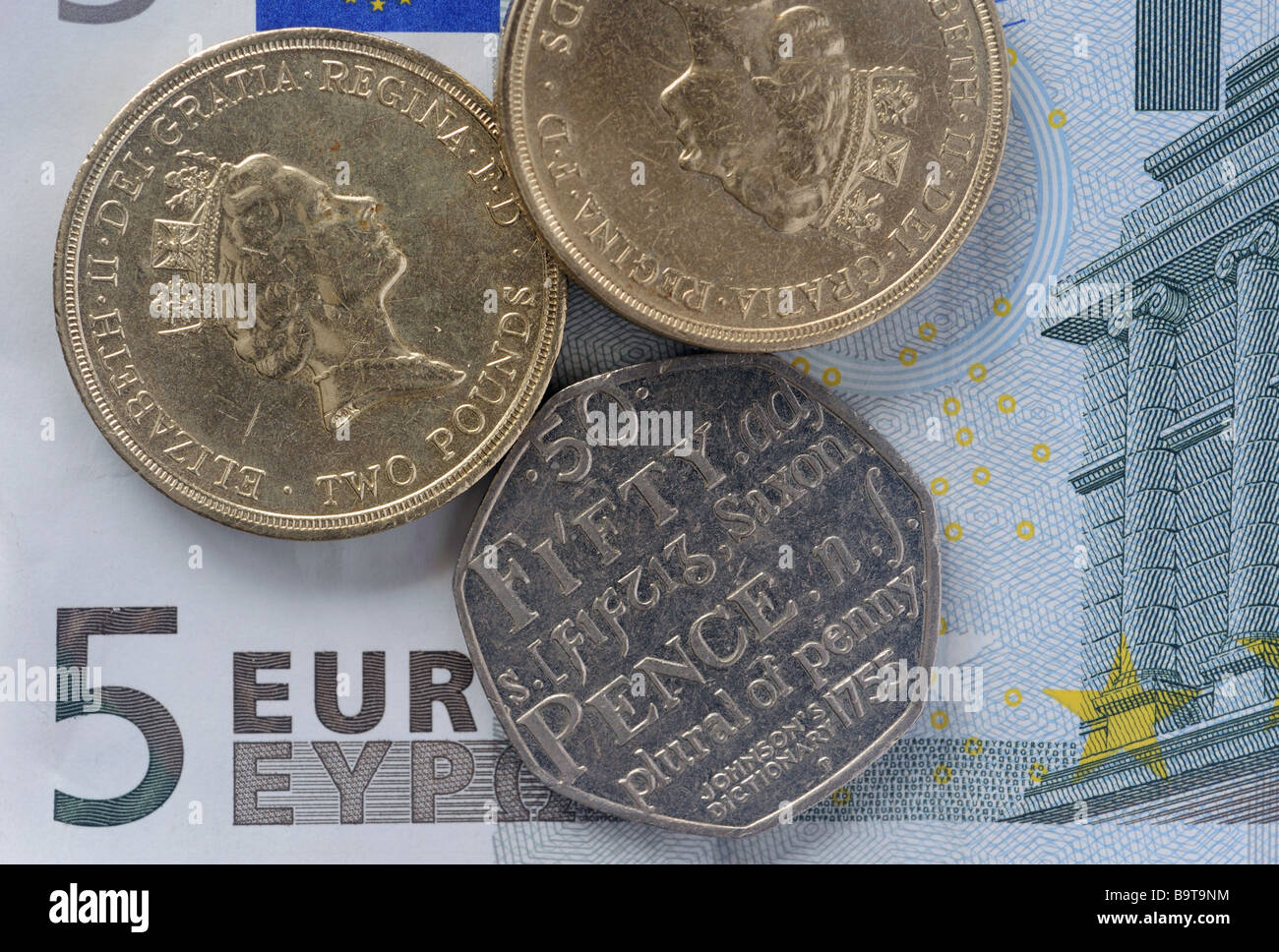 Britische Münzen auf einer Euro-banknote Stockfoto