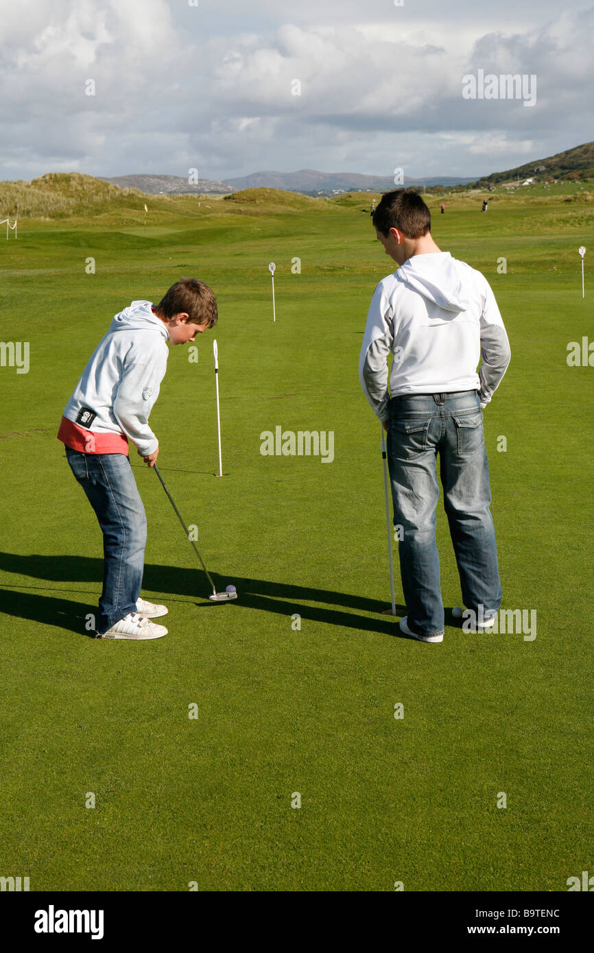 Zwei Jungs üben Golf auf dem Golfplatz an der Westküste von Donegal, County Donegal, Republik von Irland. Stockfoto