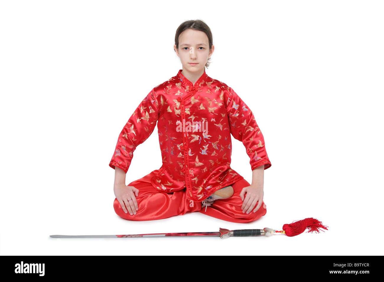 Wushu-Mädchen mit Schwert sitzt Stockfoto