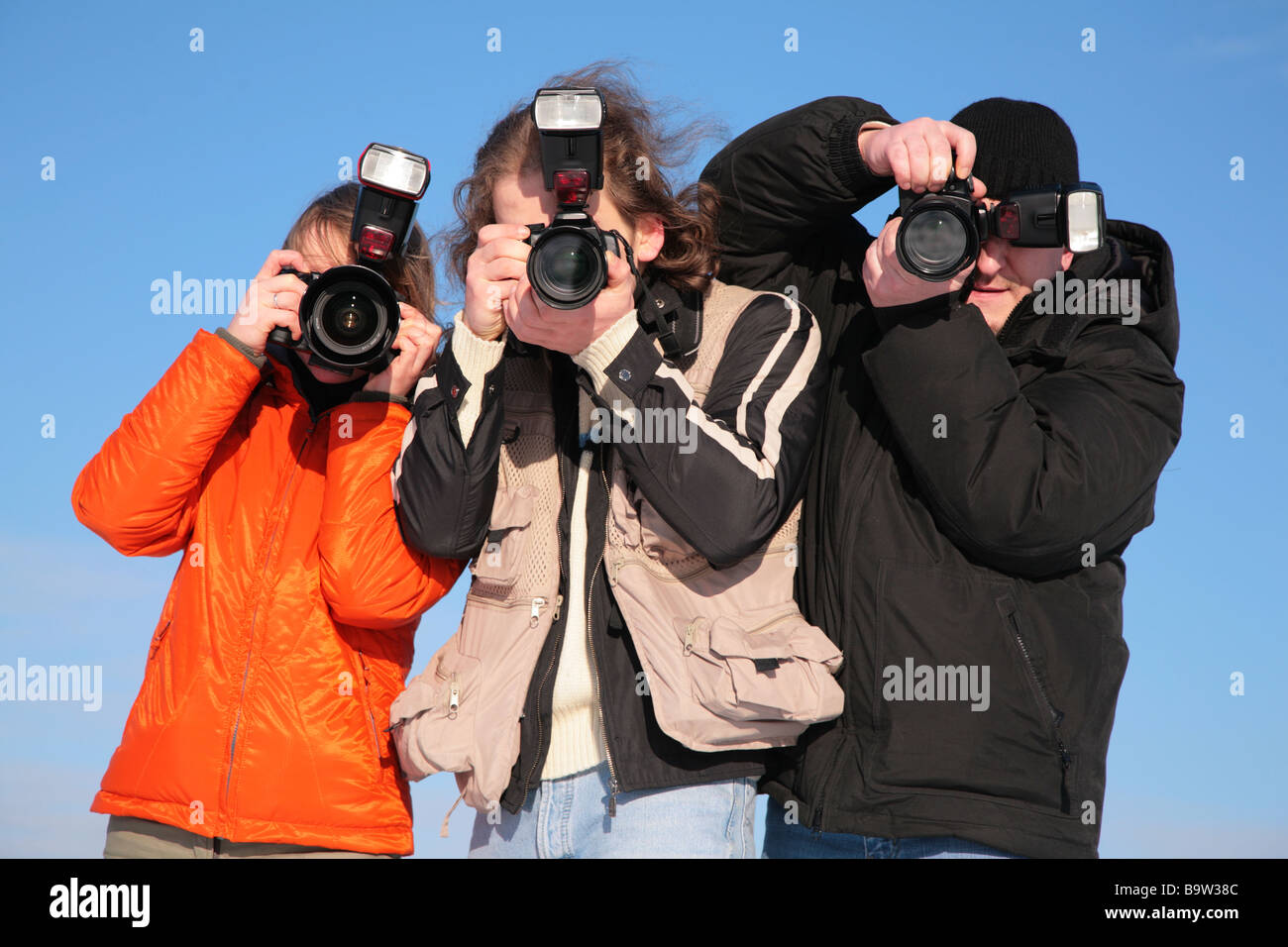 drei Fotografen gegen blauen Himmel Stockfoto