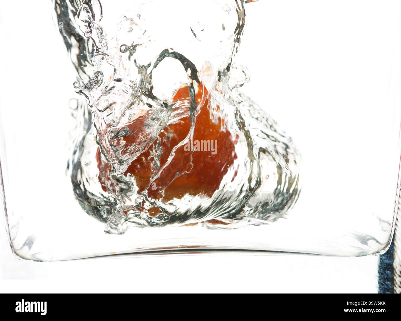 Orange in fallengelassen und umgeben von Wasser mit einer Vase-Grenze Stockfoto