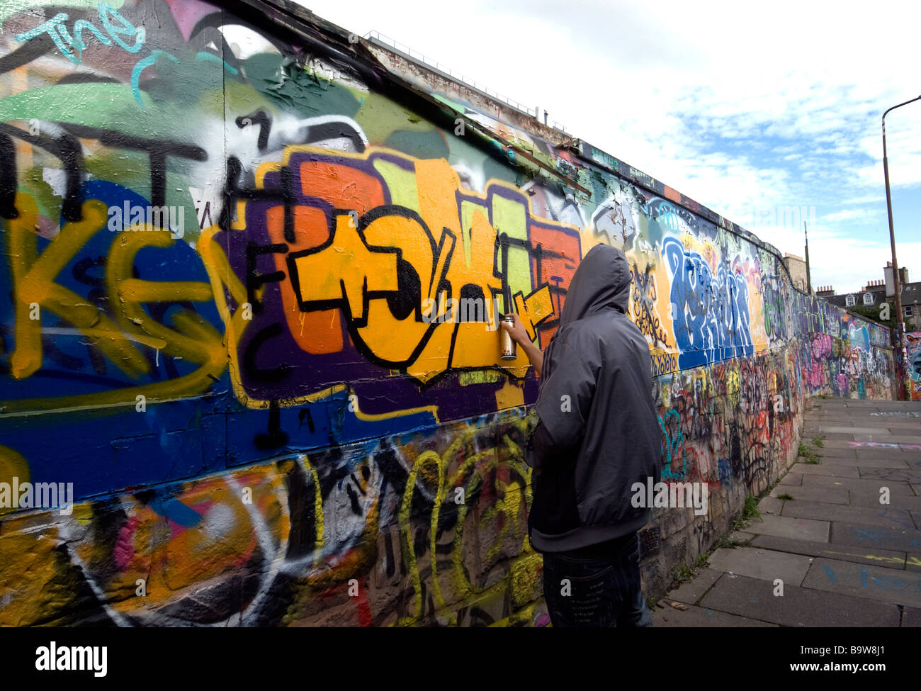 Teenager-Spray Malerei Graffiti auf Stadtmauer Stockfoto