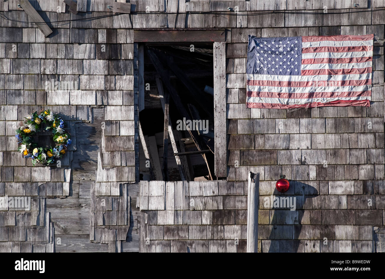 Christbaumschmuck und amerikanische Flagge auf der Seite von einem verlassenen Haus Stockfoto