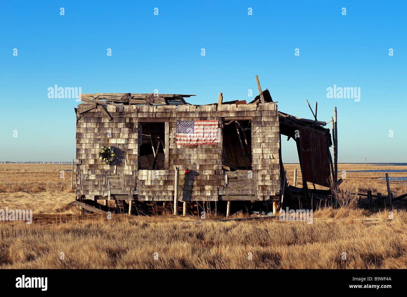 Ruiniert und Abondoned shack mit amerikanischer Flagge und Weihnachtskranz Stockfoto