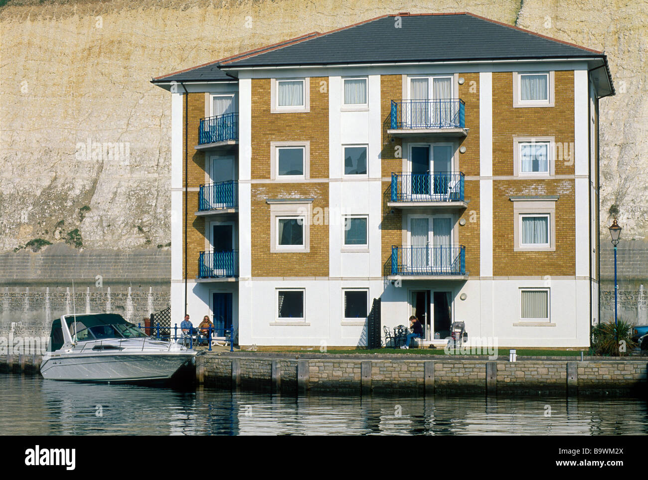 Bewohner genießen einen herrlichsten Morgen in ihre Marina Apartments mit Motorbooten vor Anker in der Nähe Stockfoto