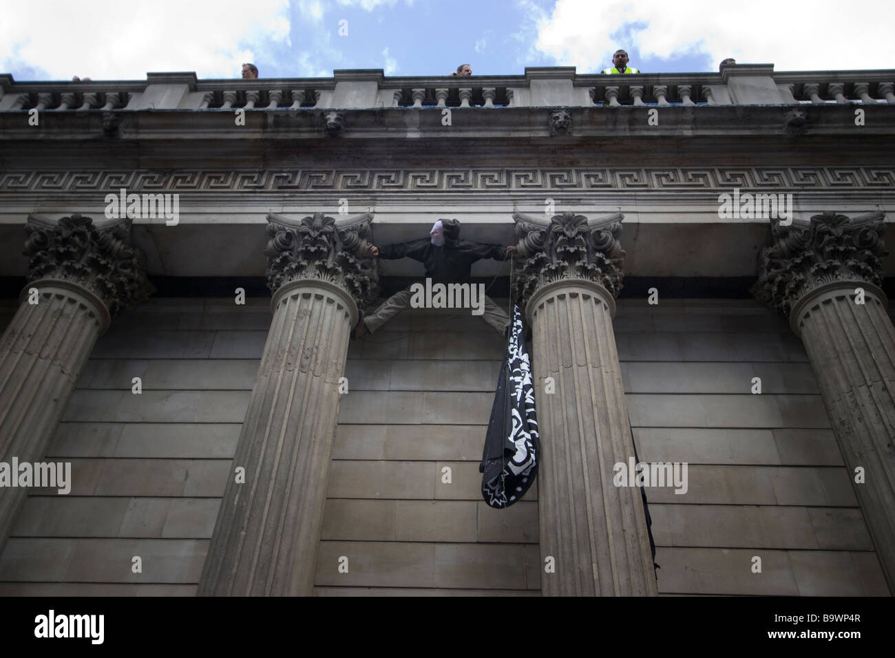 G20-Demonstration Londoner Demonstrant, der die Säulen der Bank of England überwindet, um während des Protests gegen Wirtschaftspolitik und Bankerprämien ein Banner zu platzieren Stockfoto