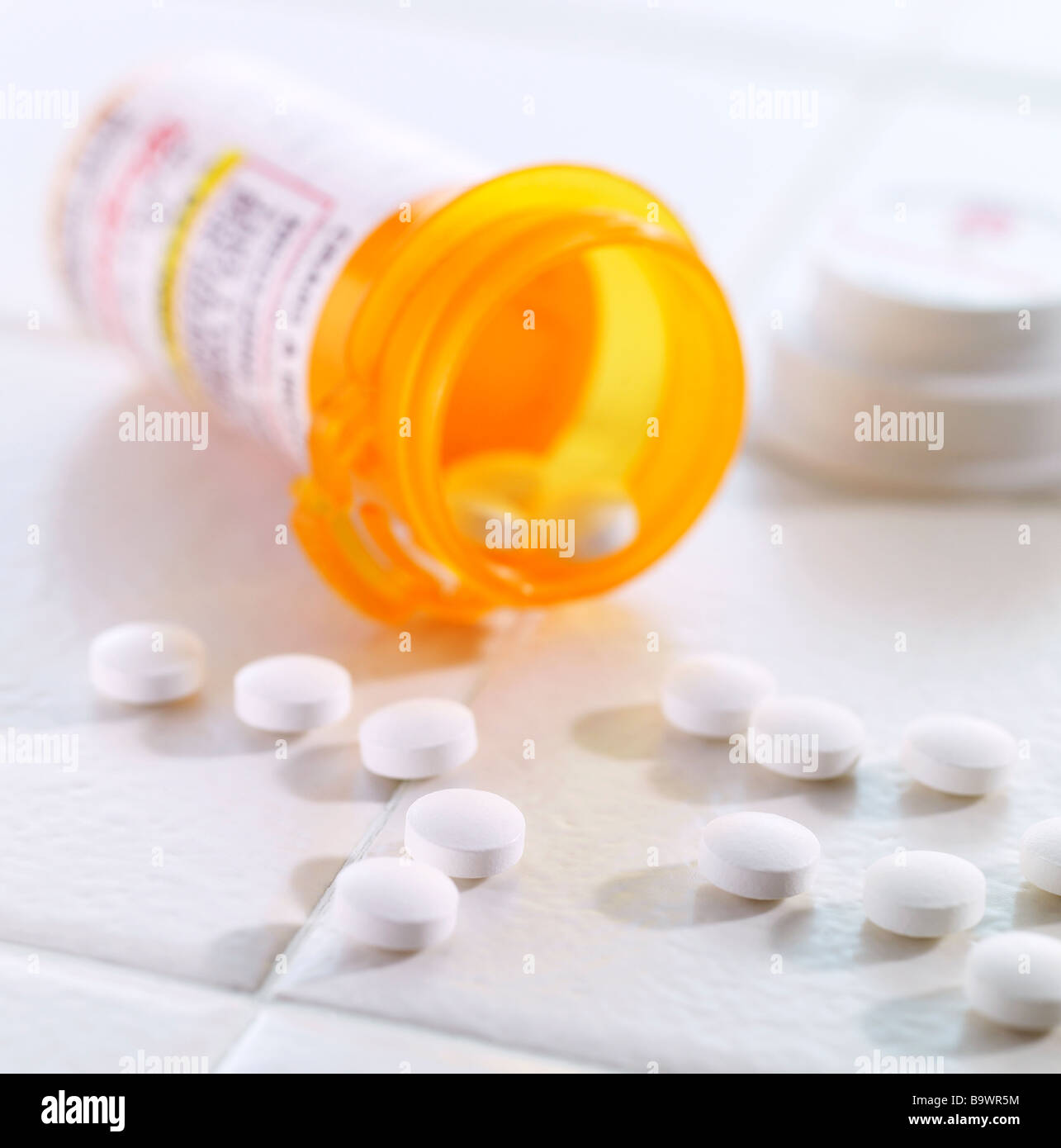 Pille-Flasche mit Pillen ergoss sich auf einer Fliese Stockfoto